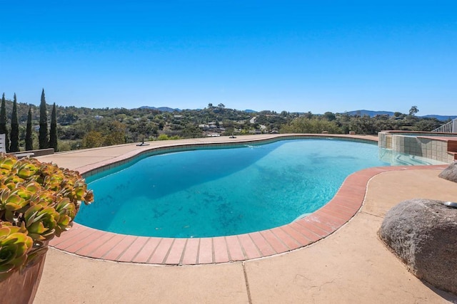 view of swimming pool with a pool with connected hot tub