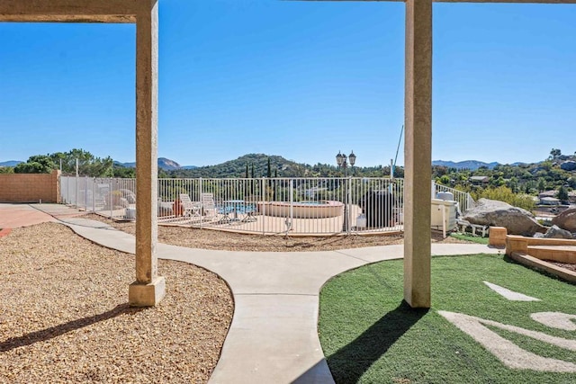 view of patio / terrace featuring fence and a mountain view