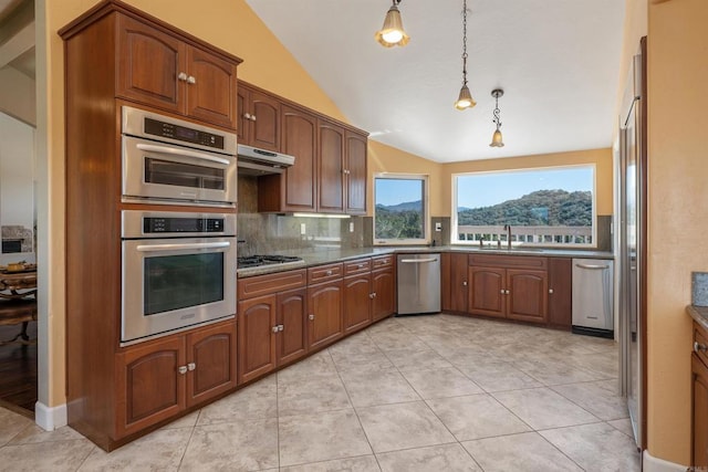 kitchen featuring decorative light fixtures, tasteful backsplash, appliances with stainless steel finishes, vaulted ceiling, and under cabinet range hood