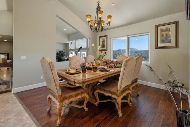 dining room with baseboards, wood finished floors, and a notable chandelier