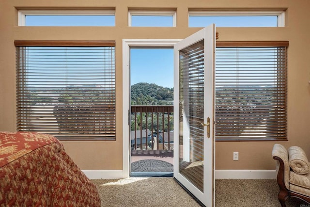 doorway featuring baseboards, carpet flooring, and french doors