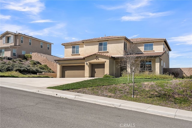 view of front of home featuring driveway, a tiled roof, an attached garage, and stucco siding