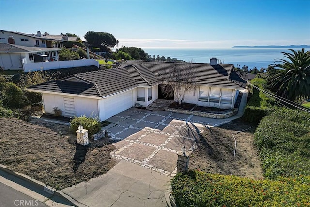 single story home with a garage, a tile roof, concrete driveway, and stucco siding