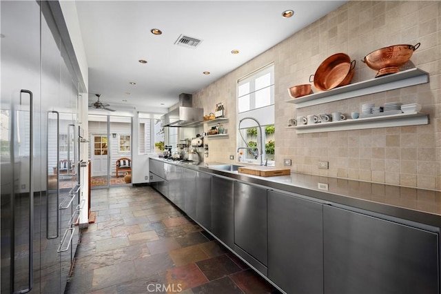 kitchen featuring open shelves, stone tile flooring, visible vents, appliances with stainless steel finishes, and wall chimney range hood