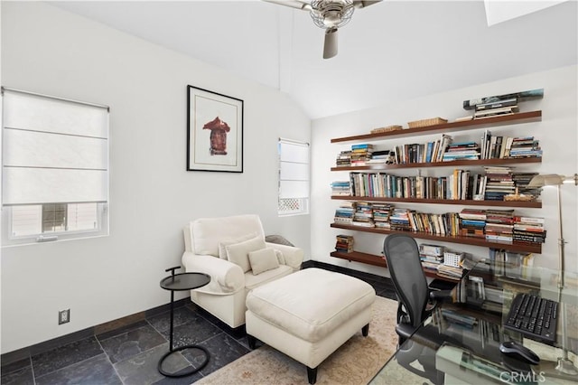 office featuring vaulted ceiling, ceiling fan, stone tile flooring, and baseboards