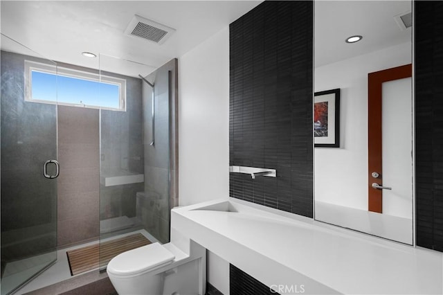 bathroom featuring a stall shower, visible vents, toilet, and recessed lighting