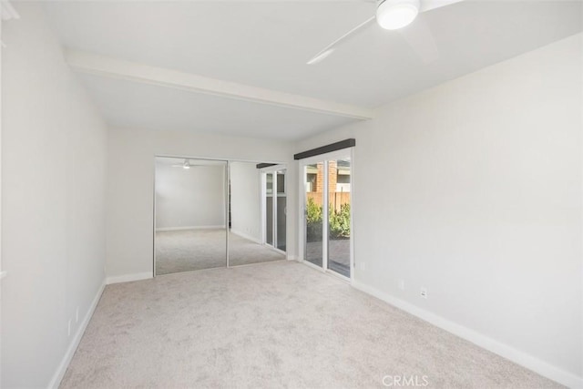 spare room featuring carpet floors, beam ceiling, ceiling fan, and baseboards