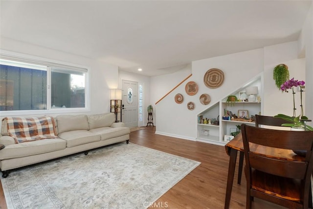 living room featuring built in features, recessed lighting, baseboards, and wood finished floors