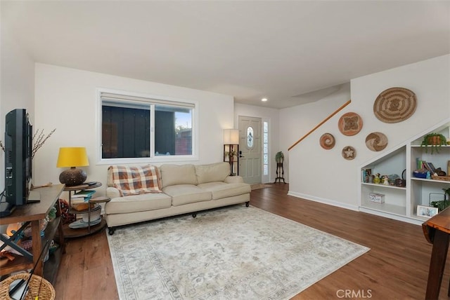 living area with baseboards and wood finished floors