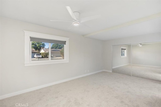 carpeted spare room with a ceiling fan, plenty of natural light, and baseboards