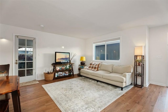 living area featuring light wood-style floors and baseboards