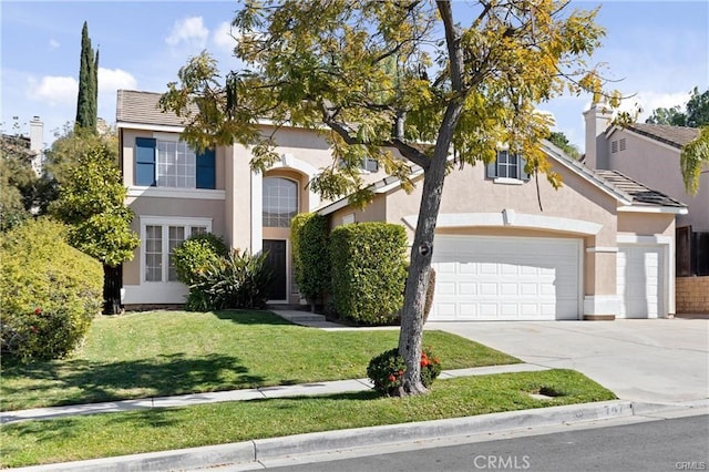 view of front facade featuring a garage, driveway, a front yard, and stucco siding