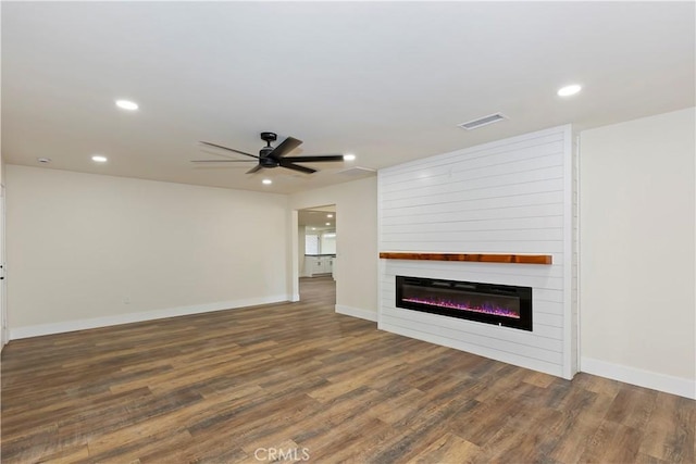 unfurnished living room featuring recessed lighting, visible vents, a large fireplace, wood finished floors, and baseboards