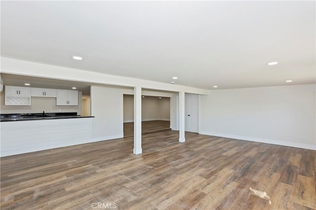 unfurnished living room with baseboards, wood finished floors, and recessed lighting