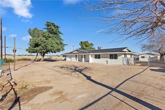 ranch-style home featuring a gate, fence, and stucco siding