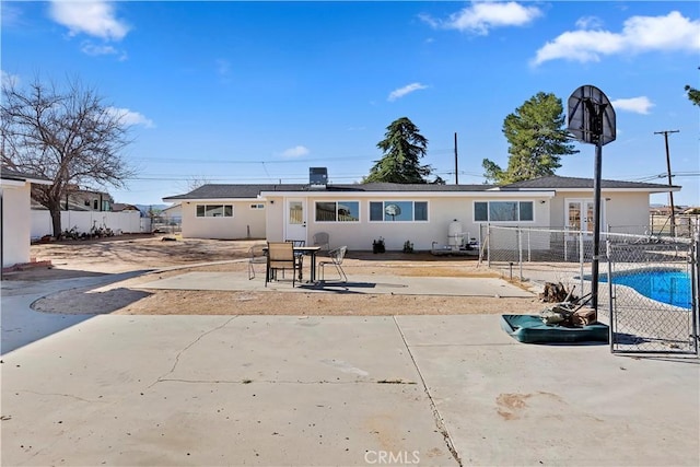 rear view of property with stucco siding, fence, and a patio