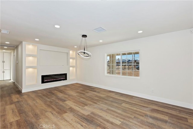 unfurnished living room featuring visible vents, baseboards, a glass covered fireplace, wood finished floors, and recessed lighting