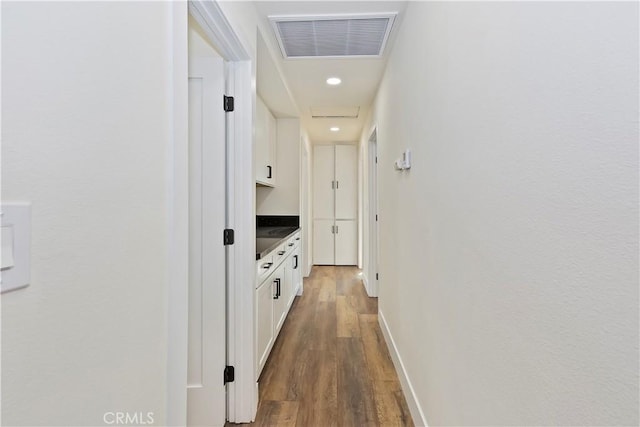 hall with recessed lighting, visible vents, baseboards, and wood finished floors