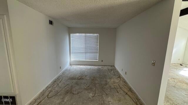 unfurnished room with visible vents and a textured ceiling