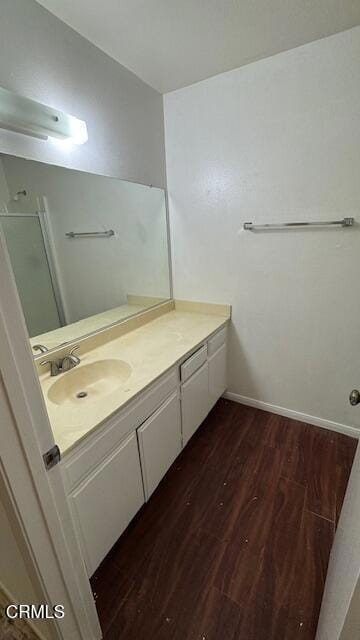 bathroom with baseboards, wood finished floors, and vanity