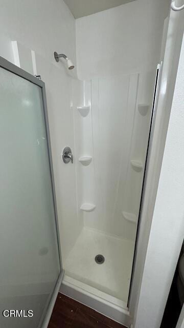 bathroom featuring a shower stall and wood finished floors