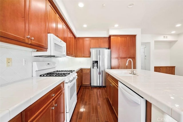 kitchen featuring tile countertops, white appliances, a sink, and dark wood finished floors