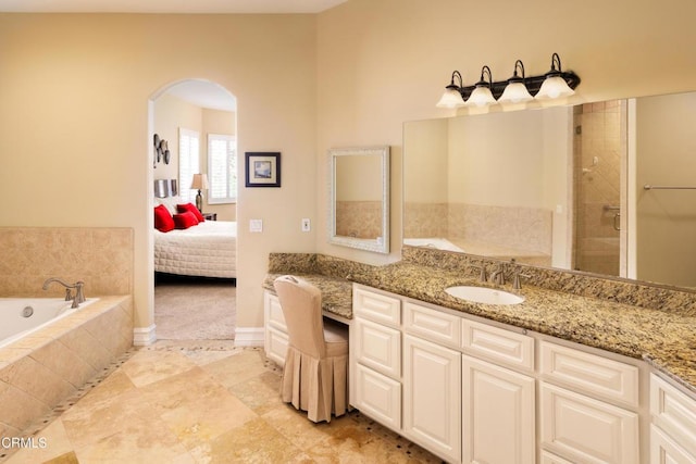 full bath featuring connected bathroom, vanity, and a bath