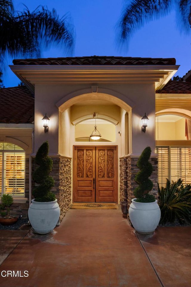 entrance to property with stone siding and stucco siding