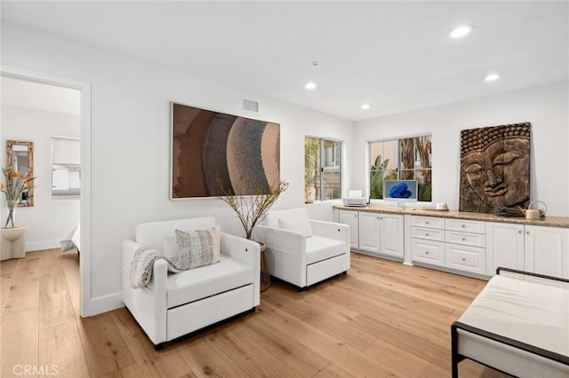 living area with light wood-type flooring, baseboards, visible vents, and recessed lighting