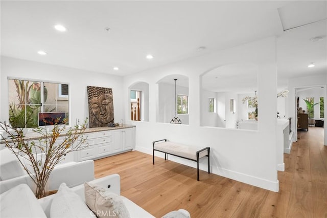 living room with light wood-style floors, recessed lighting, a wealth of natural light, and baseboards