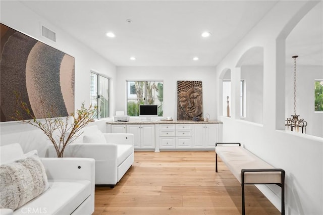 living area with plenty of natural light, recessed lighting, visible vents, and light wood-style floors