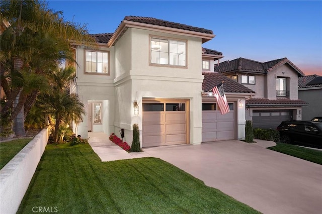 view of front of house featuring an attached garage, driveway, a front lawn, and stucco siding