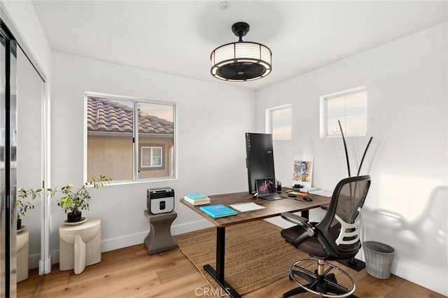 home office featuring light wood-type flooring and baseboards