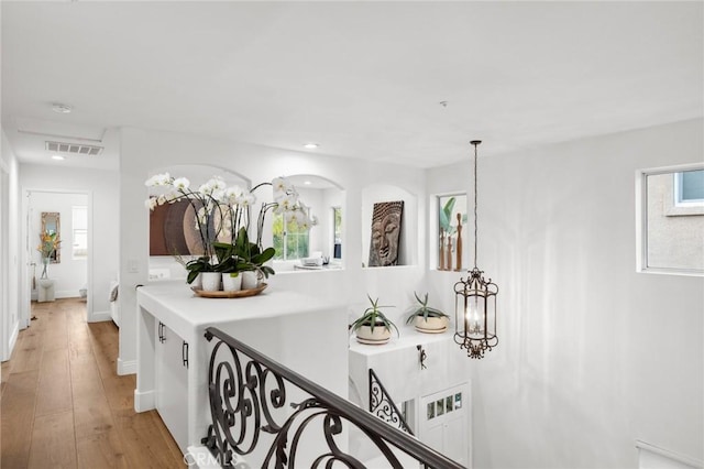 hallway with light wood-style floors, baseboards, and recessed lighting