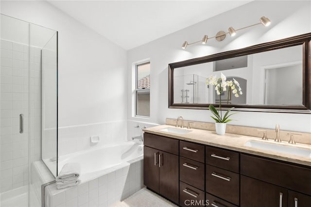 bathroom featuring double vanity, a sink, a bath, and a shower stall