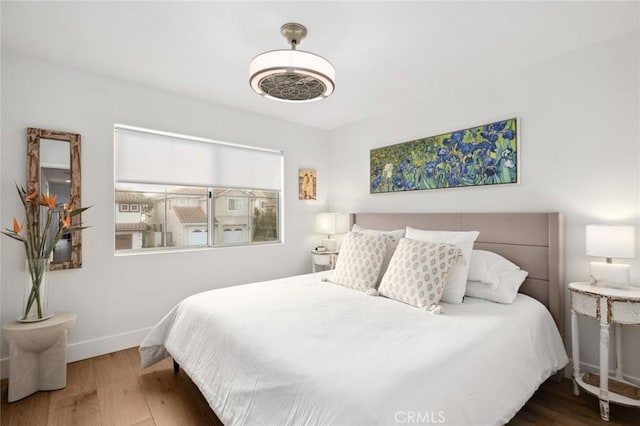 bedroom with wood finished floors and baseboards