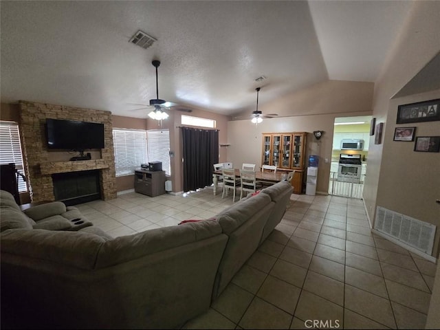 living area featuring a fireplace, tile patterned flooring, and visible vents