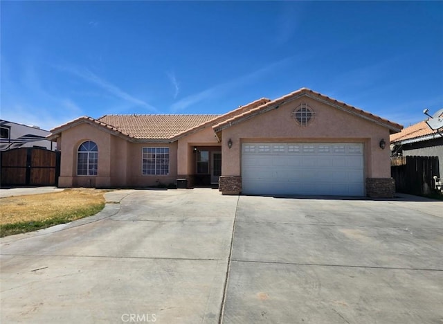 view of front of home featuring a tile roof, driveway, stucco siding, and fence