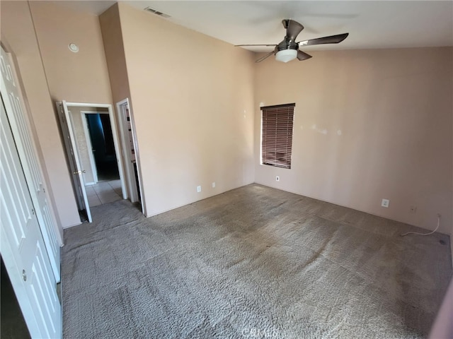 empty room with a ceiling fan, visible vents, and carpet