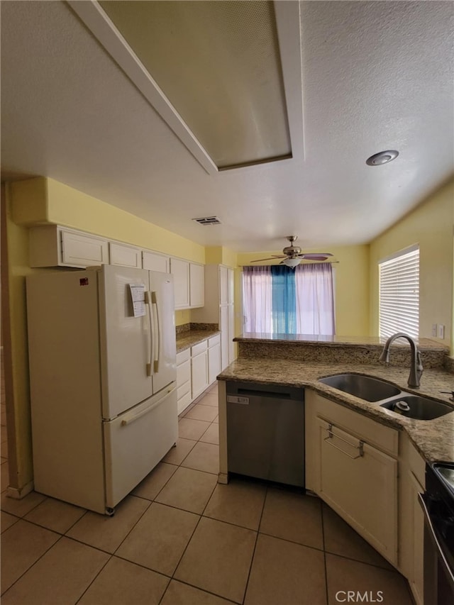 kitchen featuring white cabinets, range with electric stovetop, stainless steel dishwasher, a sink, and freestanding refrigerator
