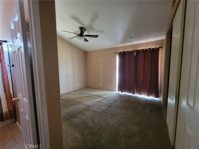 unfurnished bedroom featuring lofted ceiling, a ceiling fan, and carpet