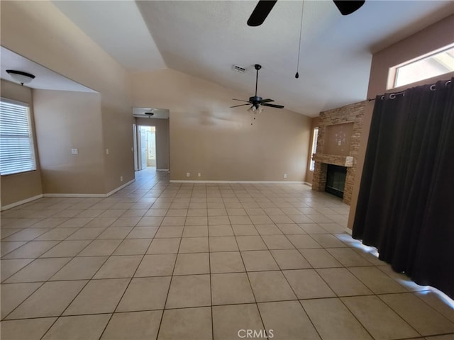 unfurnished living room featuring lofted ceiling, a ceiling fan, a large fireplace, and light tile patterned flooring