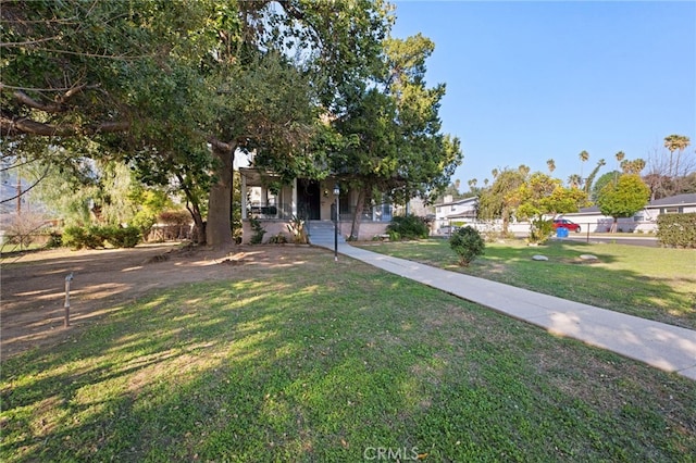 obstructed view of property with a front yard and covered porch