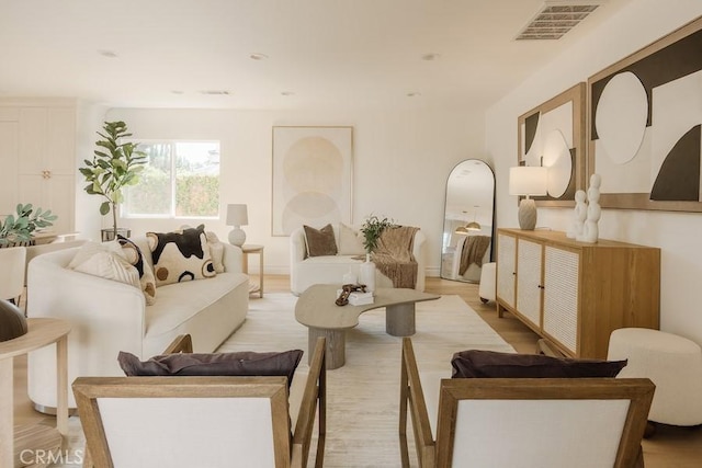 living area featuring light wood finished floors and visible vents