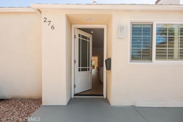 entrance to property featuring stucco siding