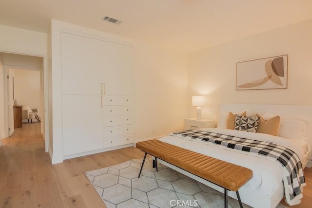 bedroom featuring light wood-style flooring and visible vents