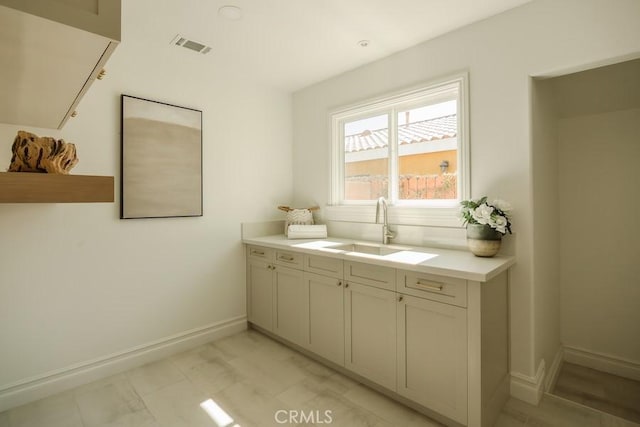 bathroom featuring a sink, visible vents, and baseboards