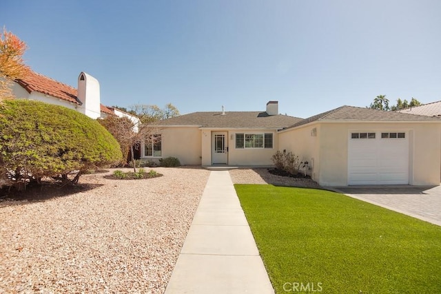 ranch-style house with stucco siding, a front lawn, decorative driveway, and a garage