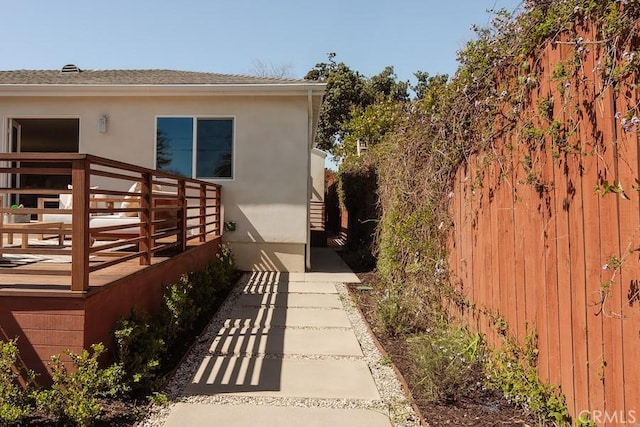 view of side of property with fence and stucco siding