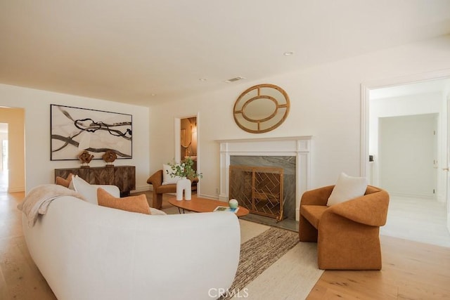 living room featuring a high end fireplace and wood finished floors